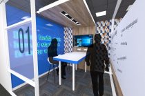 Design for a meeting room at McKesson including large computer screen, meeting table and silhouettes of workers